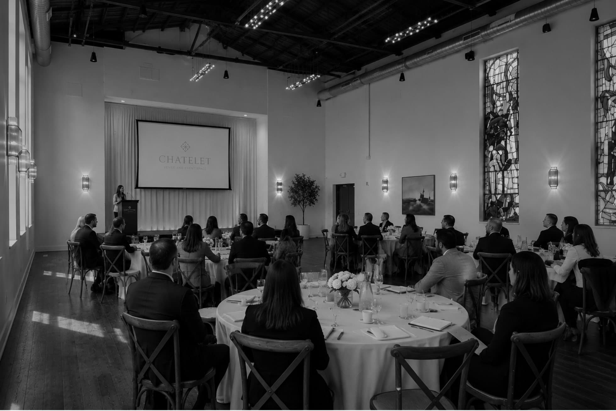 A seated corporate audience watching a presentation in the Châtelet hall